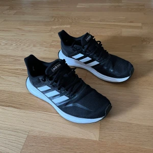 Svarta Adidas sneakers - Säljer svarta Adidas löparskor. Perfekt för löpning eller vardagsbruk. Bekväma och stilrena. Storlek 41 1/3.