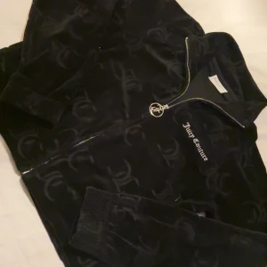 Svart velourjacka från Juicy Couture - Snygg svart velourjacka från Juicy Couture med dragkedja och broderad logga på bröstet. Storlek M kort modell. Aldrig använd! 