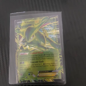 Pokémonkort Virizion EX - Säljer ett Pokémonkort med Virizion EX. Kortet har HP 170 och förmågan 'Verdant Wind'. Attacken 'Emerald Slash' ger 50 skada. Kortet är i en skyddande plastficka.