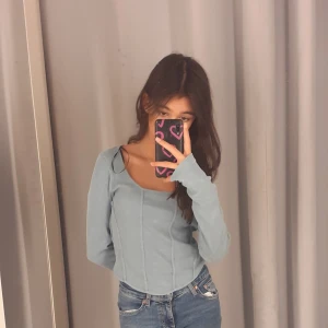 Ljusblå långärmad topp - Säljer en stilren ljusblå långärmad tröja då den aldrig kommit till användning. (Förutom här på bilden då)💗  Är  i storlek XS 💕