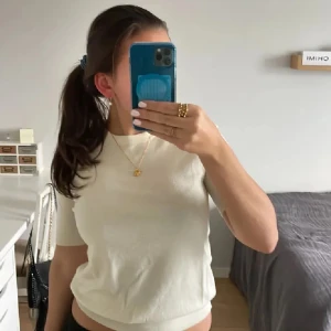 Vit kortärmad topp från Zara - Stickad, creme vit 3/4 tröja från Zara med små gulliga knappar där bak. Passar till allt och bra skick. Passar som både S och M.