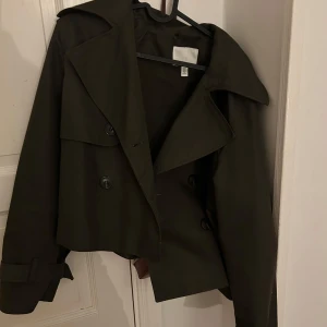 Trenchcoat från HM - Snygg mörkgrön trencoat , knappt använd , inte några större defekter. 