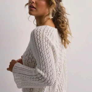 Vit stickad tröja - Säljer en vacker vit stickad tröja med ett detaljerat mönster. Tröjan har långa ärmar och en rund halsringning. Perfekt för en stilren och mysig look. Aldrig använd 