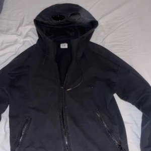 C.P. Company hoodie - Säljer min C. P. Company hoodie då den tyvärr inte passar mig. Köpt här på plick för ett tag sedan. Man ser att den är något använd, därav priset. Nypris 2699 kr, och priset kan diskuteras! Hör av dig vid övriga frågor. 