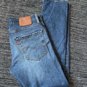 Levis 501 jeans - Klassiska blå Levis 501 jeans med rak passform och midwaist. Tillverkade i slitstarkt denim med den ikoniska läderpatchen på baksidan. Perfekta för en tidlös stil.