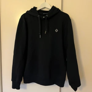 Mörkblå hoddie från Morris - Mörkblå Morris hoodie i bra skick i storlek M. Nypris på 1 500 kronor.