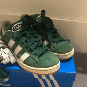 Gröna Adidas Campus sneakers - Snygga gröna Adidas Campus sneakers med gröna snören som är oanvända men man får även med vita och smalare gröna snörren dem är i stolek 41/1,3 kontakta om du vill ha fler bilder eller svar på frågor 