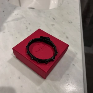 Valentino armband svart - Snyggt svart armband från Valentino med nitar! Kommer i en elegant röd ask. Och är i storleken Onesize! Nypris ligger på 3085kr och armbandet är sparsamt användt utan några defekter och allt og medföljer! Skriv vid intresse ! 
