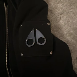 Moose knuckles kofta - Jätte skön och varm kofta för killar, har svart päls inuti, går att ta av och på luvan. Säljer den åt min kille då han inte använder den längre💗priset kan diskuteras! Koftan är tjock och kan även användas som jacka 