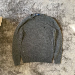 Ralph lauren tröja  - Säljer snygg stickad Ralph lauren tröja i storlek S. Den är mörkgrå o har inga defekter. Har mått i bild så ni kan se hur den passar
