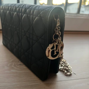 Dior lady pouch i svart med guldfärgad kedja - Lady Dior Pouch i svart. Kostar 22800 kr på hemsidan. Inköpt från vestiaire collective, finns äkthetsbevis. Finns även  verifiering från vestiaire.