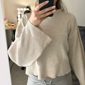 Beige tröja  - Ljusbeige tröja med vid arm samt hög krage. Först till kvarn. Säljer då jag har flera liknande. 