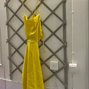 Klänning shein - En gul klänning med tunna axelband som korsas i ryggen. Klänningen har en lös passform och en A-linjeform. Den är använd 1 gång och är från Shein!