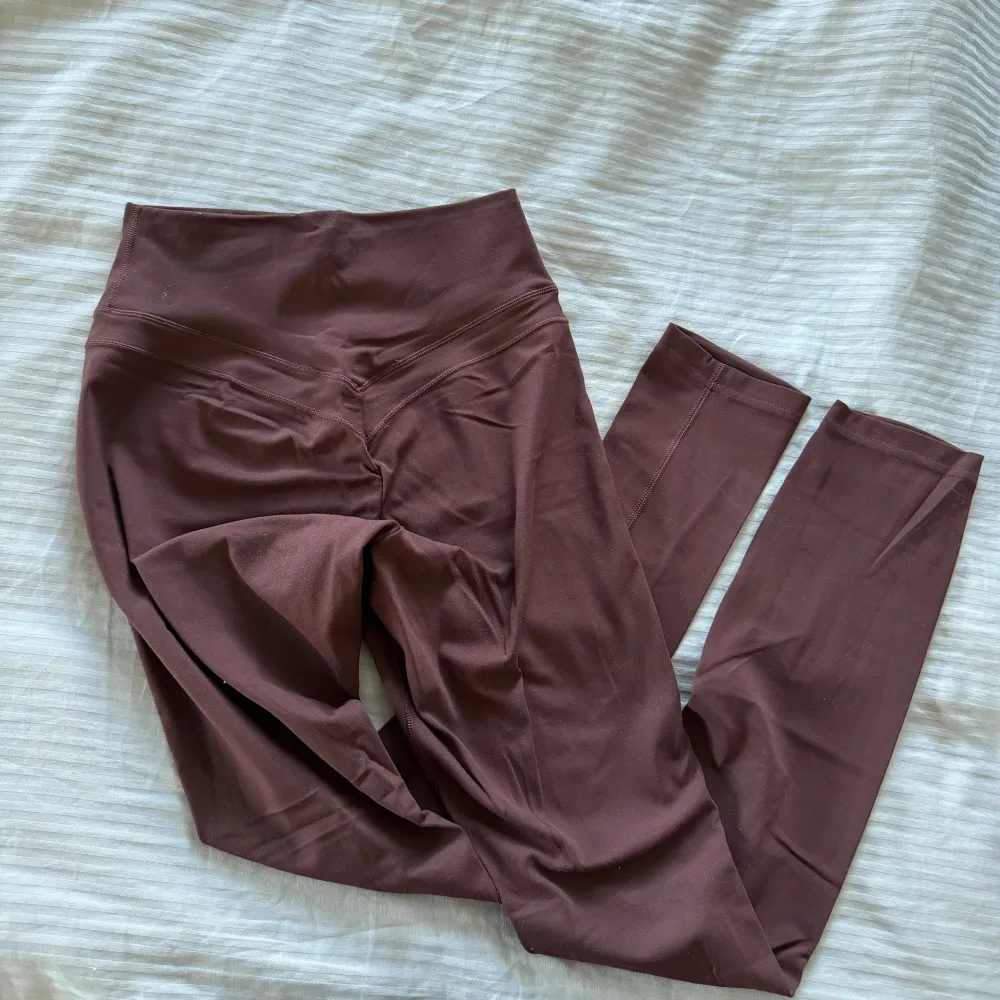 Jättefina mörkröda/bruna tights från Gymshark. Använda Max 3 gånger så inga skador eller slitningar! Klippt bort lappen där bak men är storlek XS.. Sportswear.