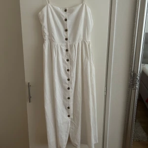 Vit långklänning  - Jätte fin vit klänning med knappar från HM som går precis under knäna. I strl 40. I bra skick, prislapp är kvar och aldrig använd pga den inte passade mig. 