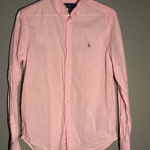 Ralph lauren skjorta - Den är storlek 18-20 vilket motsvarar längden 170-177cm… den är i riktigt fint skick, färgen är rosa riktigt sctheeeek PRIS:329kr… Mvh Borgs Closet 