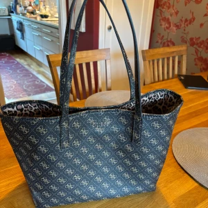 Guess väska  - Säljer min nästan helt oanvända Guess handväska. Den har en liten väska som kan användas för sig eller kopplas inuti den stora. Den är helt äkta och har inga defekter alls