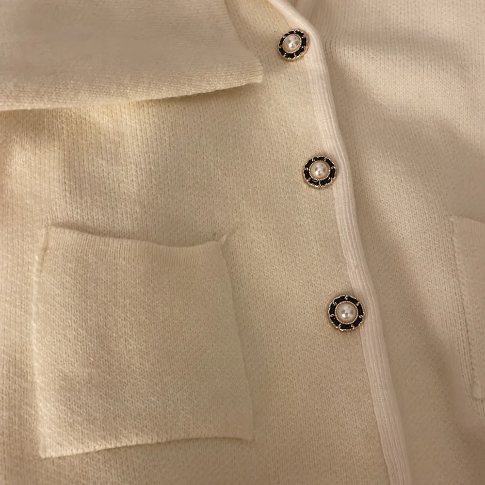 Säljer en elegant kofta med unika pärlknappar. Den har en elegant design med långa ärmar och en mjukt material. Perfekt för att vara lite finare i vardagen eller för att klä upp dig! Bara använd en gång och har inga tecken på användning<3 pris kan diskuteras. Neuletakit & Villapaidat.