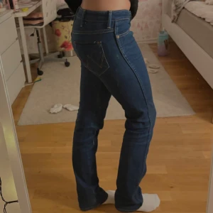Blå Lågmidjade jeans - Snygga blå lågmidjade jeans från Wrangler, passar perfekt på mig som är 167! Skriv för mått på jeansen!