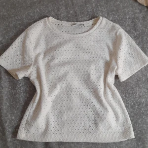 Vit kortärmad topp från Zara - Säljer en söt vit topp från Zara med korta ärmar och ett fint hålmönster. Perfekt för sommaren💘