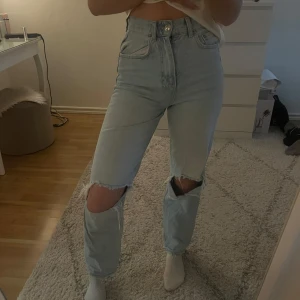  jeans med slitningar - Snygga ljusblå jeans med hög midja och slitningar vid knäna. 