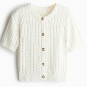 Vit stickad kofta med korta ärmar - Säljer en stilren vit stickad kofta med korta ärmar och fina knappar framtill. Storleks XS. Skriv för egna bilder❤️