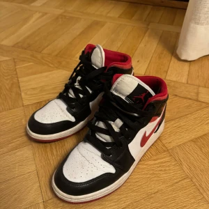 Nike Air Jordans i svart, vitt och rött - Snygga Nike Air Jordans i klassisk färgkombination av svart, vitt och rött. Skorna har ett bra skick tros andvända ett par 10 gånger.