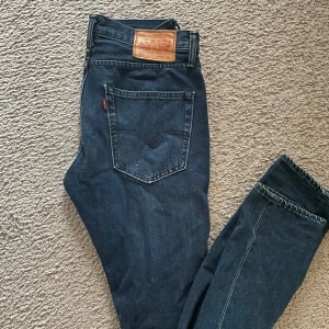 Levi's 512 jeans i mörkblå denim - Säljer ett par Levi's 512 jeans i mörkblå denim. De har en klassisk femficksdesign. Perfekta för en stilren look med en smal passform. Skriv vid funderingar 