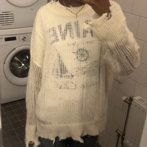 Vit stickad tröja - Säljer en vit stickad tröja. Tröjan har en avslappnad passform och är långärmad med en rå kantdetalj. Perfekt för en vanlig skol outfit. (Har en vanlig t shirt under ej till salu) 🩷Tröjan påminner lite om Acnes stickade tröja☺️