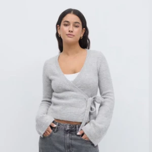 Grå omlottkofta från Gina Tricot - Säljer den populära knitted wrap cardigan från Gina Tricot i premiumkvalitet som är slutsåld i nästan alla storlekar. Andvänd endast ett fåtal gånger!