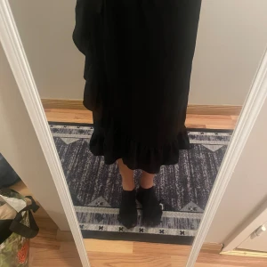 Svart kjol  från ONLY - Säljer en elegant svart kjol från ONLY med volangdetaljer vid fållen. Perfekt för en stilren look. Kjolen  har en klassisk design som passar till många tillfällen.