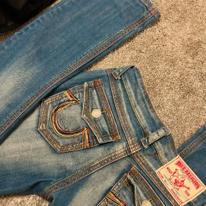 True Religion jeans - Svin coola raka/slim True Religion jeans med ikoniska broderade detaljer på bakfickorna🔥Säljer då jag ätit lite mycket marabou under senaste och de inte passar längre💔💔Jeansen är i storlek W26, och passade mig som vanligtvis bar XS-S💞 Köpt från Vinted och inga defekter förekommer🫶