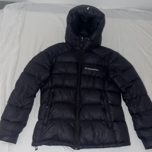 Svart dunjacka från Peak Performance - Säljer en svart dunjacka från Peak Performance. Jackan har en hög krage och dragkedja framtill. Den passar både på män o kvinnor då jag själv har använt den. Den kostar runt 4000 tusen i nypris. Säljer den för att den har blivit för liten 