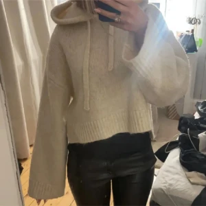 Beige stickad hoodie - Säljer en mysig beige stickad hoodie med croppad passform. Den har långa ärmar och en stor huva med knytband. Från zara