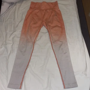 Leggings/tights ICANIWILL - Snygga oranga/aprikosa leggings från ICANIWILL med hög midja och en ombre-effekt som går från orange till ljusare nyanser. Märker på benet har nötts lite men inget man tänker på