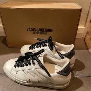Vita sneakers från Zadig & Voltaire - Snygga vita sneakers från Zadig & Voltaire med svarta detaljer och snörning. 