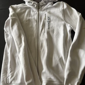 Vit jacka från Sail Racing - Säljer nu denna sail racing zip hoodien i strl 176 (skick 3/10) väldigt snygg men det är en fläck på vänster armen+ lite slitage på armbågarna priset går att förhandla. Hör av dig vid frågor! Passar S
