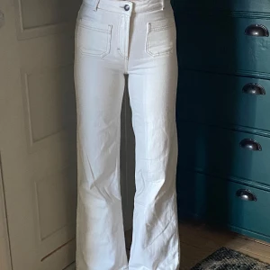 Vita jeansbyxor från Twist & Tango - Snygga vita jeansbyxor från Twist & Tango med hög midja och bootcut-stil. Byxorna har snygga fickor på framsidan och bruna sömmar 🤎🤍🤎🤍