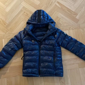 Glansig Peak performance jacka - En glansig och fin peak performance jacka perfekt till höst och vinter. Inga defekter förutom att den har någon ihopsydd ”patch” som knabbt syns alls. Storlek 160 men sitter som xs 