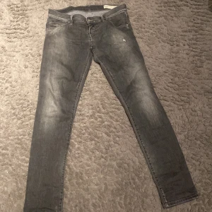 Grå Diesel jeans - Säljer ett par grå Diesel Grupee jeans i  slim passform. De har en stretchig känsla och några snygga slitningar. Säljer för de är för små för mig. Skick 10/10.