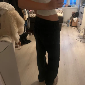 Svarta byxor - Säljer ett par svarta byxor i bra skick. De är lågmidjade och har en normal passform. Perfekta för vardagsbruk och kan enkelt matchas med olika toppar. Byxorna är bekväma och stilrena, ett måste i garderoben!