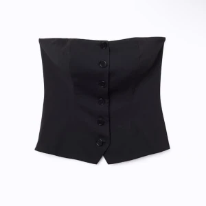 Svart korsett med knappar - Säljer denna helt oanvända svarta korsett low waist med knappar framtill, axelbandslös. Köptes för 399kr 😊