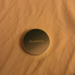 Clarins Ombre 4 Couleurs 05 - Säljer en Clarins ögonskuggspalett med fyra intensiva och långvariga färger. Paletten har en elegant design och innehåller nyanser i mörka och neutrala toner. Perfekt för att skapa både vardagliga och festliga looks. Den är ultra-pigmenterad och har en slät, fin textur.