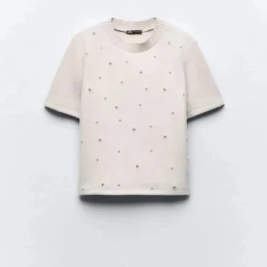 Vit kortärmad tröja med pärlor - Säljer en superfin vit tröja från Zara med korta ärmar och små pärlor över framsidan. Den har en ribbad rund halsringning som ger en extra touch. Passar perfekt till jeans eller kjol! Har bara använt en gång säljer för 150 som fast pris💕