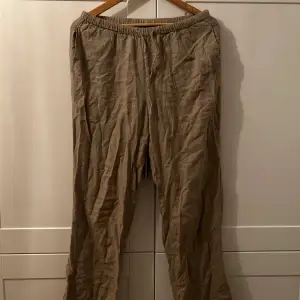 Säljer ett par bekväma beige linnebyxor i loose fit. Perfekta för sommardagar med sin lätta och luftiga känsla. Byxorna har en elastisk midja för extra komfort. Passar både till vardags lappande tillfällen. Använt ofta men i bra skick.🏖️