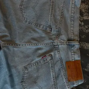 Säljer ett par klassiska Levi's 501 jeans i ljusblå denim. De har en rak passform och är i mycket bra skick. Perfekta för alla tillfällen. 