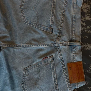 Levi's 501 ljusblå jeans - Säljer ett par klassiska Levi's 501 jeans i ljusblå denim. De har en rak passform och är i mycket bra skick. Perfekta för alla tillfällen. 