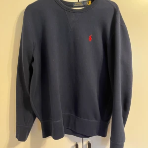 Ralph Lauren sweatshirt  - Säljer en snygg mörkblå tröja från Polo Ralph Lauren i mycket bra skick. Perfekt för både vardag och lite finare tillfällen. Superbekväm och stilren!