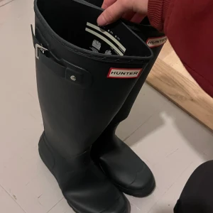 Svarta stövlar från Hunter - Säljer ett par av de populära, klassiska svarta Hunter-stövlarna i tall. Stövlarna är dammodell i storlek 39. Saknar original kartong men lapp har jag kvar🌟 Nypris 1599:-