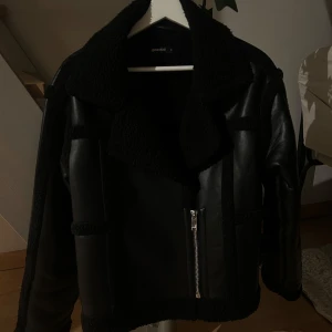 Svart skinnjacka med foder - Säljer en snygg svart skinnjacka från Zara med mjukt foder. Jackan har en dragkedja framtill och långa ärmar. Perfekt för höst och vinter när du vill hålla dig varm och stilren. Passar både till vardags och fest!